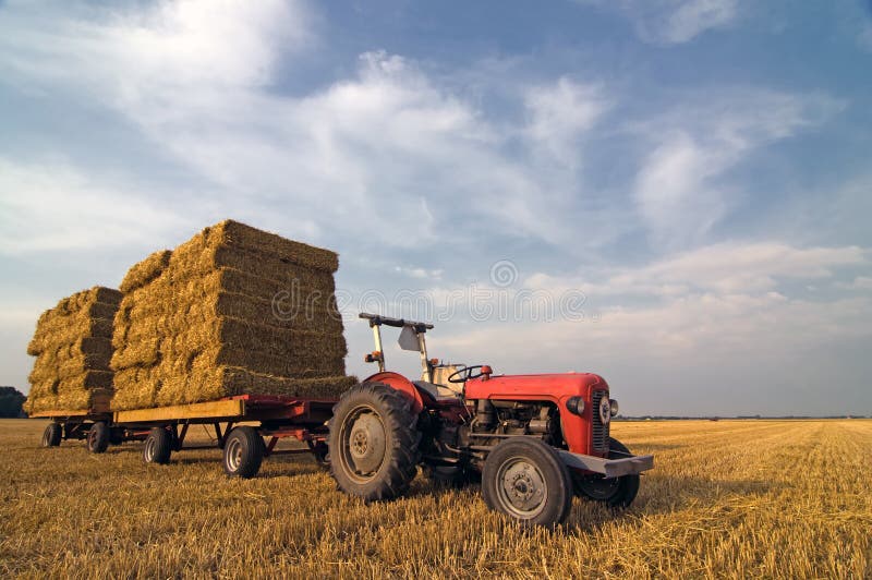 Agricultural Equipment red tractor with straw on t stock photos