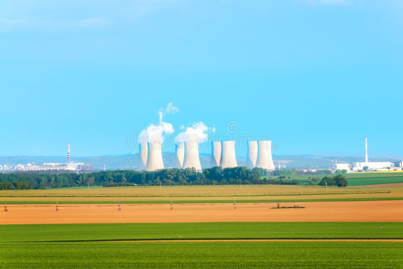 Agricultural fields with cooling towers of nuclear power plant in background