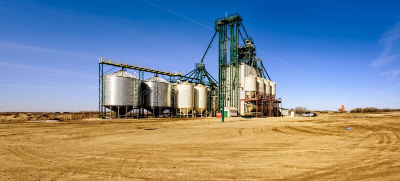 agricultural industrial complex for cleaning and processing grain against the blue sky and yellow soil