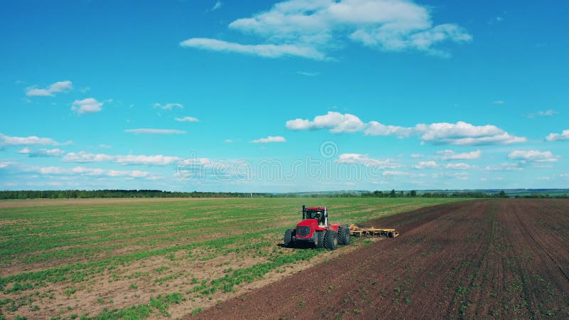 Agricultural tractor plows ground for seeds planting.