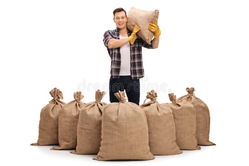 Agricultural worker standing behind burlap sacks and holding a s. Ack on hi...