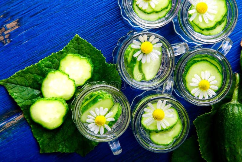 Agua del pepino en seis tarros de cristal del pequeño albañil en fondo azul rústico Visión superior Detox fotografía de archivo Agua del pepino en seis tarros de cristal del pequeño albañil en fondo azul rústico Visión superior Detox fotografía de archivo