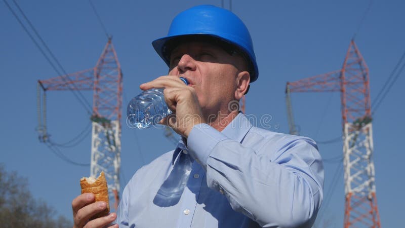 Agua dulce de Drink del ingeniero sediento y comer un bocado fotos de archivo Agua dulce de Drink del ingeniero sediento y comer un bocado fotos de archivo