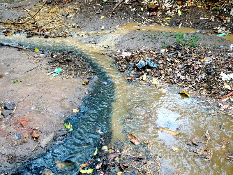 Agua negra del dren y el fluir fangoso amarillo del agua del suelo imagen de archivo libre de regalías Agua negra del dren y el fluir fangoso amarillo del agua del suelo imagen de archivo libre de regalías