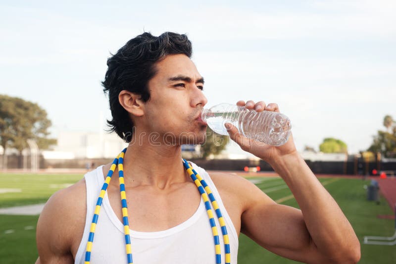 Agua potable del atleta de sexo masculino joven del latino