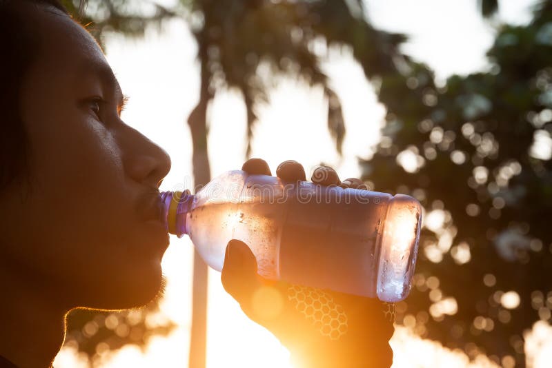 Agua potable del hombre asiático deportivo de la botella Deporte y sano fotos de archivo libres de regalías Agua potable del hombre asiático deportivo de la botella Deporte y sano fotos de archivo libres de regalías