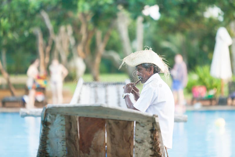 Ahungalla, Sri Lanka - An old native flute player sitting on traditional longboat royalty free stock photography Ahungalla, Sri Lanka - An old native flute player sitting on traditional longboat royalty free stock photography