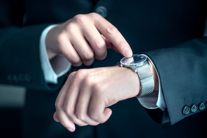 Ai grijă la încheietura unui om de afaceri elegant. om de afaceri ocupat care se uită la timp. stres sau grabă la locul de muncă. royalty free stock image