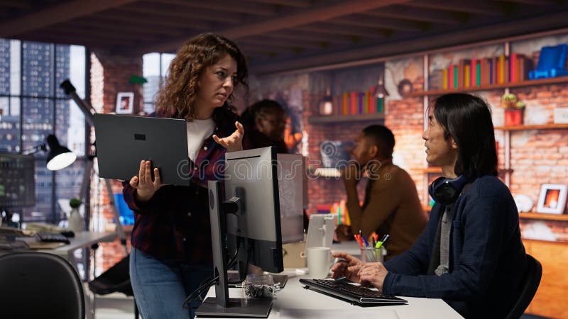 AI startup intern holding laptop asks questions to senior technician stock photos