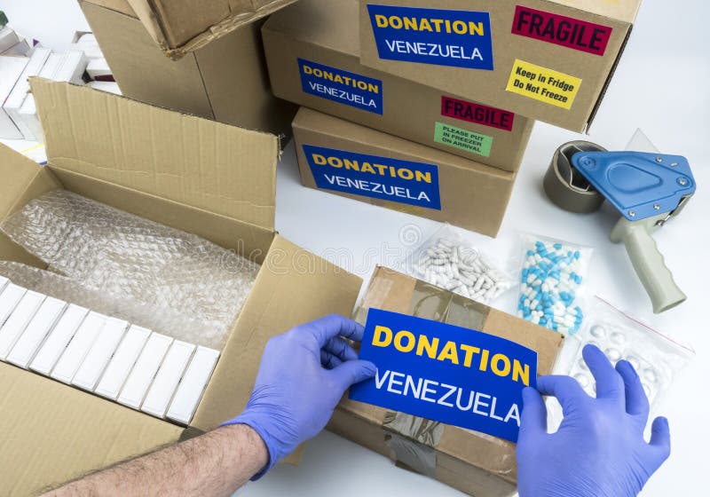 Aide humanitaire, infirmière plaçant le médicament de donation de label pour envoyer le Venezuela image libre de droits Aide humanitaire, infirmière plaçant le médicament de donation de label pour envoyer le Venezuela image libre de droits