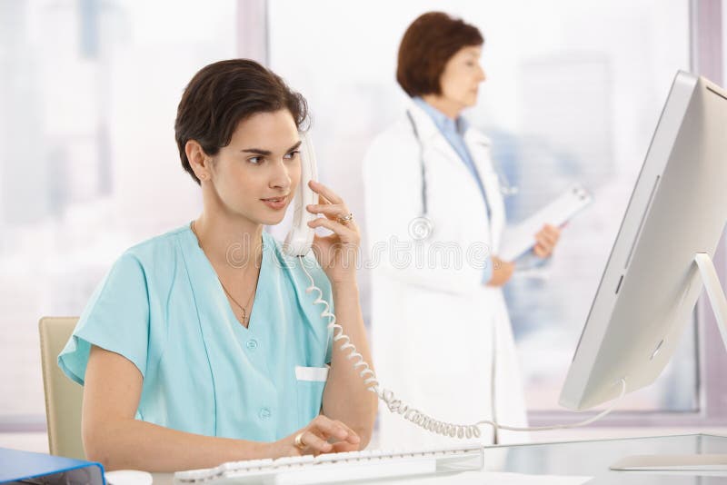 Aide médical au téléphone, utilisant l'ordinateur images stock Aide médical au téléphone, utilisant l'ordinateur images stock