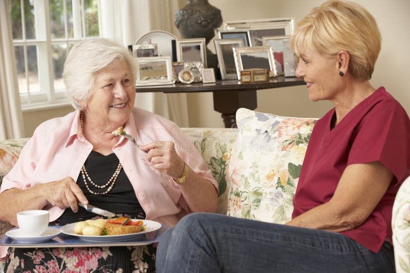 Aide servant la femme supérieure avec le repas dans la maison de soin photographie stock libre de droits Aide servant la femme supérieure avec le repas dans la maison de soin photographie stock libre de droits