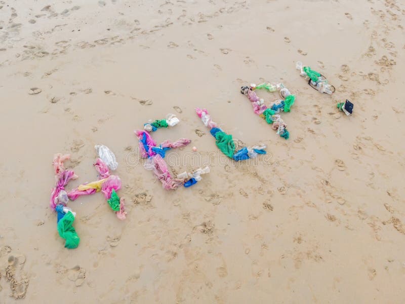 Aidez la correction faite à partir des déchets sur la plage photographie stock libre de droits