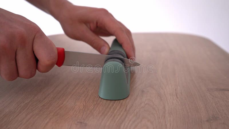 Aiguiser les mains masculines un couteau avec un aiguiseur 4k métrage stock. clips vidéos