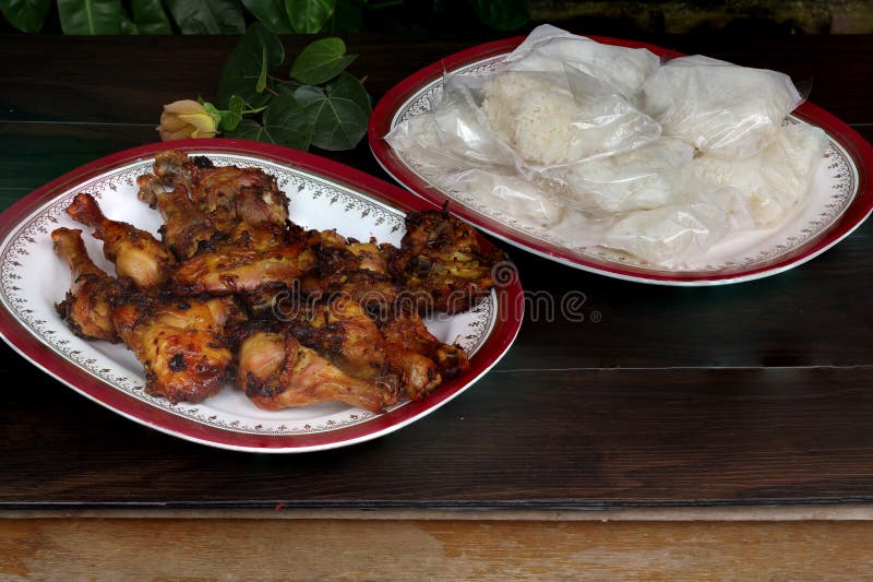 Ailes de poulet cuites au four avec du riz visqueux sur le Tableau en bois photos stock Ailes de poulet cuites au four avec du riz visqueux sur le Tableau en bois photos stock