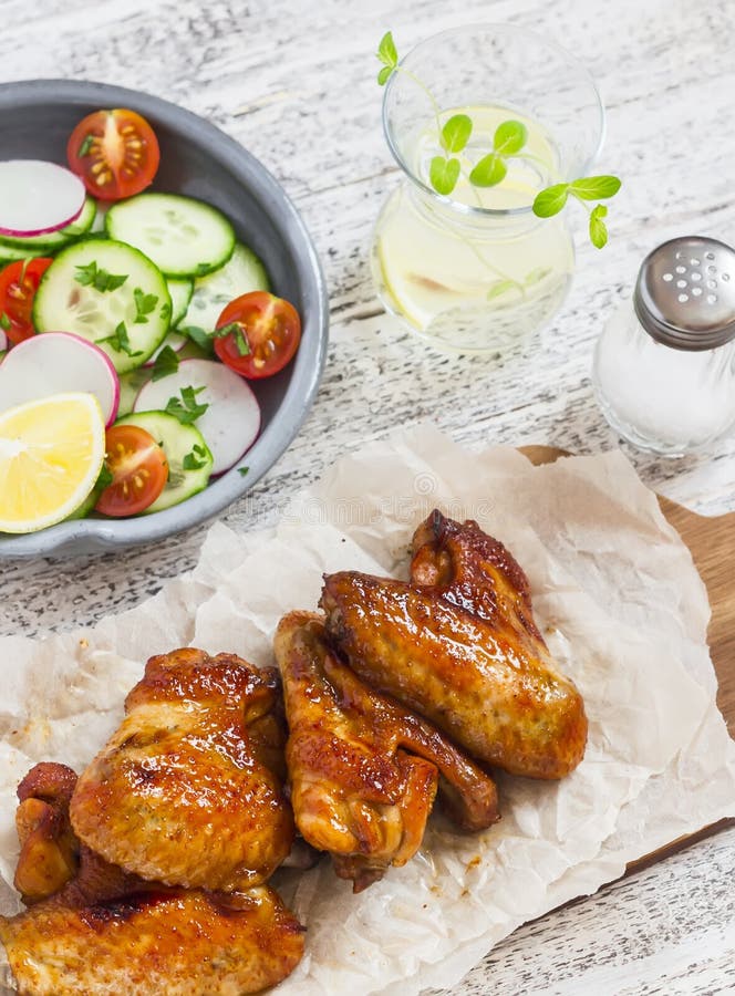 Ailes de poulet épicées et salade de légume frais images libres de droits Ailes de poulet épicées et salade de légume frais images libres de droits