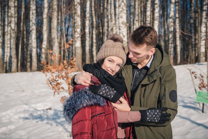 Aimer un jeune beau couple dans le parc par une journée ensoleillée Un jeune homme embrasse et réchauffe sa petite amie photos libres de droits Aimer un jeune beau couple dans le parc par une journée ensoleillée Un jeune homme embrasse et réchauffe sa petite amie photos libres de droits