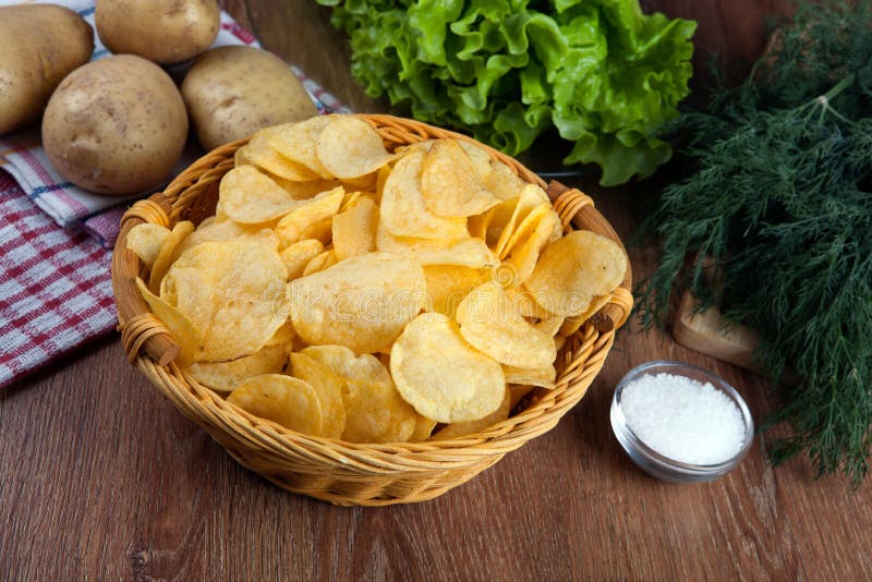 Ainda vida de uma bacia de vidro com microplaquetas de batata foto de stock royalty free Ainda vida de uma bacia de vidro com microplaquetas de batata foto de stock royalty free