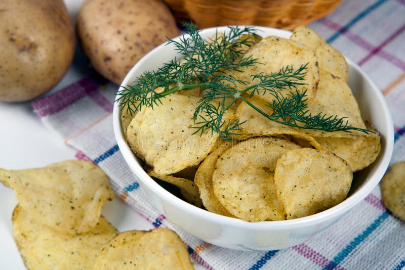 Ainda vida de uma bacia de vidro com microplaquetas de batata fotos de stock Ainda vida de uma bacia de vidro com microplaquetas de batata fotos de stock