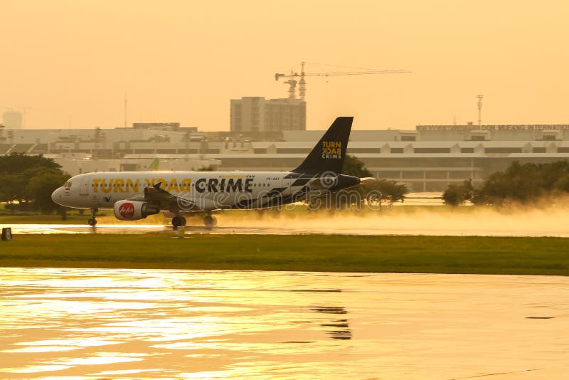 Air Asia Airbus A320, registrazione PK-AXY, gira indietro la livrea di crimine, decolla da una pista bagnata dell'aeroporto inter immagine stock libera da diritti Air Asia Airbus A320, registrazione PK-AXY, gira indietro la livrea di crimine, decolla da una pista bagnata dell'aeroporto inter immagine stock libera da diritti