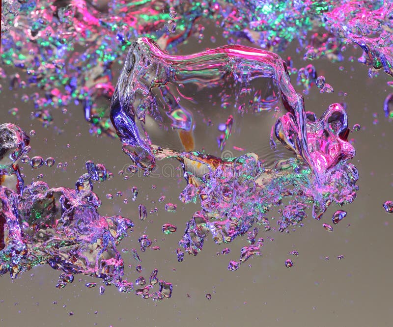 Macro view of colorful air bubbles in water, gray background.