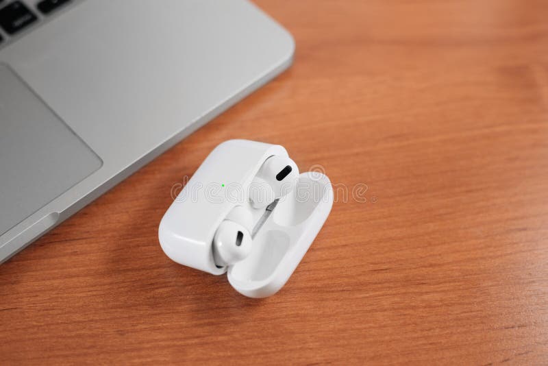 Air Pods Pro. macbook. with Wireless Charging Case. New Airpods pro on wooden background. Airpods. Copy space