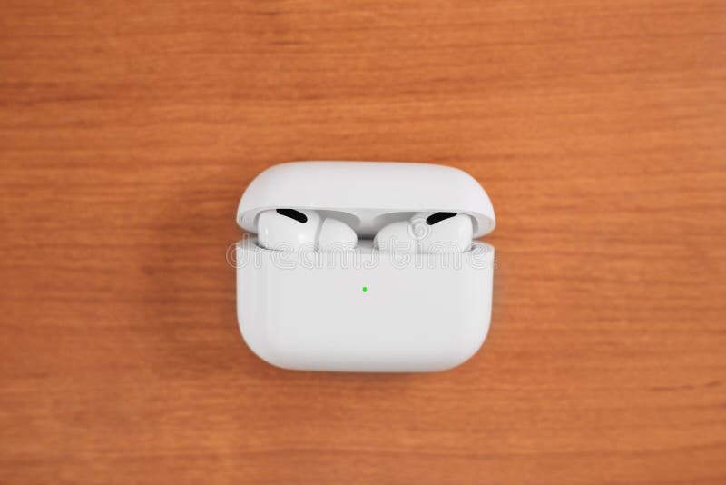 Air Pods Pro. with Wireless Charging Case. New Airpods pro on wooden background. Airpods. Copy space