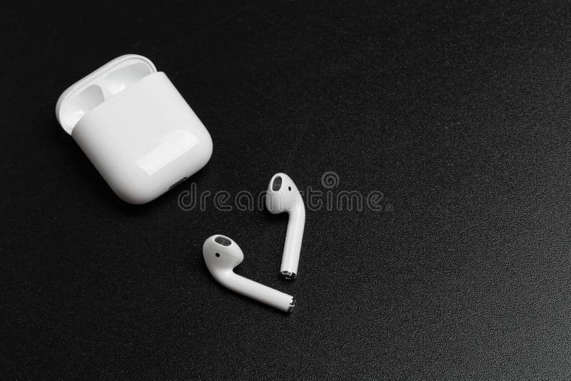 Air Pods with Wireless Charging Case. New Airpods 2019 on black background. entangled 3.5 headphones - Image