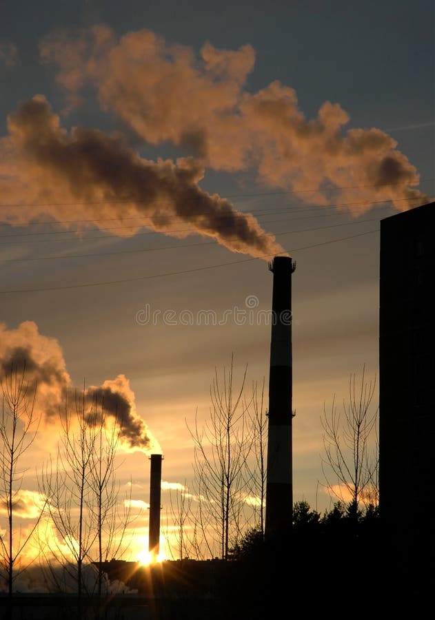 Inquinamento sputa in aria dai camini industriali, al tramonto.