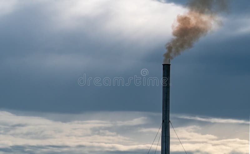 Air pollution from factory. Smoke from chimney of industrial pipe on sunset sky. Global warming problem concept. Bad air quality.