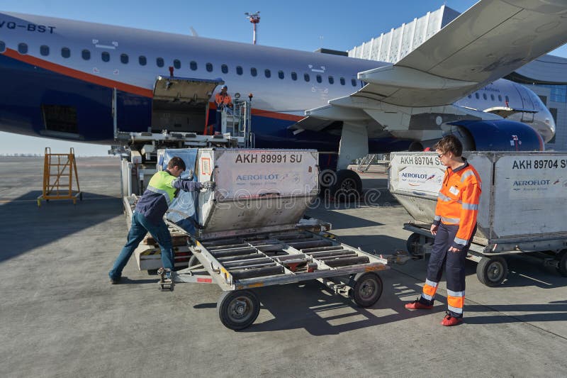 Aircraft of the Aeroflot Airbus VQ-BST during loading and unloading operations, preparing for the flight at the parking lot of stock photo
