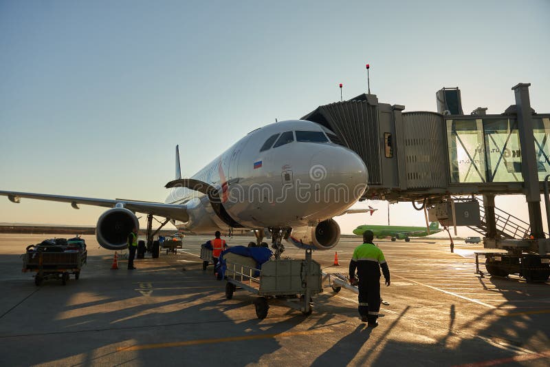 Aircraft of the Aeroflot Airbus VQ-BST during loading and unloading operations, preparing for the flight at the parking lot of stock photo