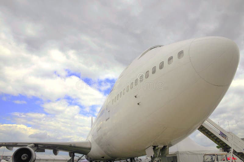 Un aereo rimanere aeroporto nuvoloso il cielo.