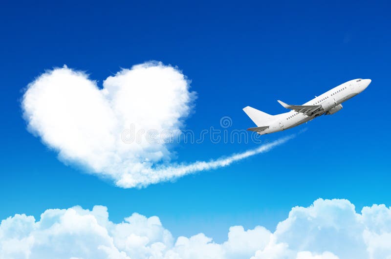 Airplane in the blue sky with clouds, left a trace in the form of a cloud of the heart.