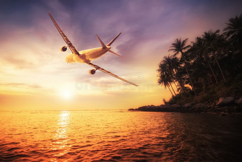 Airplane flying over amazing tropical sunset landscape stock photos Airplane flying over amazing tropical sunset landscape stock photos