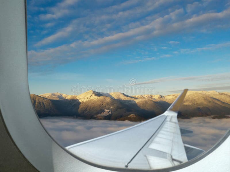 Airplane flying over mountains, beautiful view from window royalty free stock photo