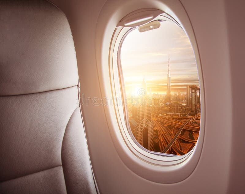 Airplane interior with window view of Dubai city