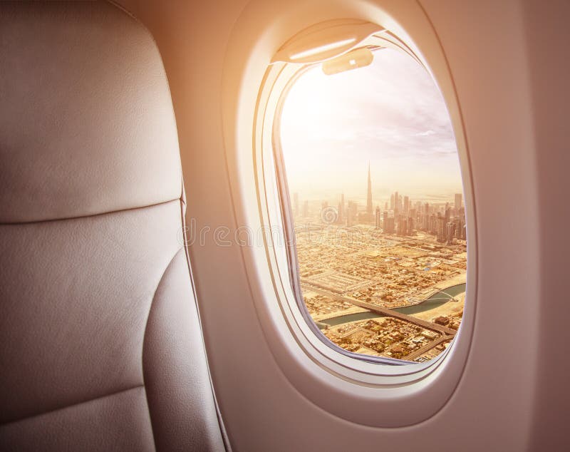 Airplane interior with window view of Dubai city