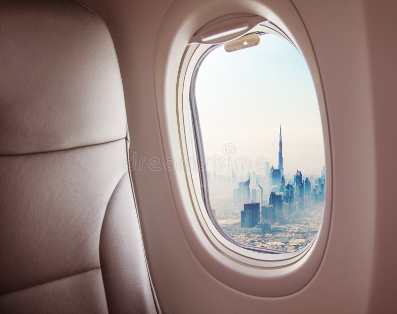 Airplane interior with window view of Dubai city