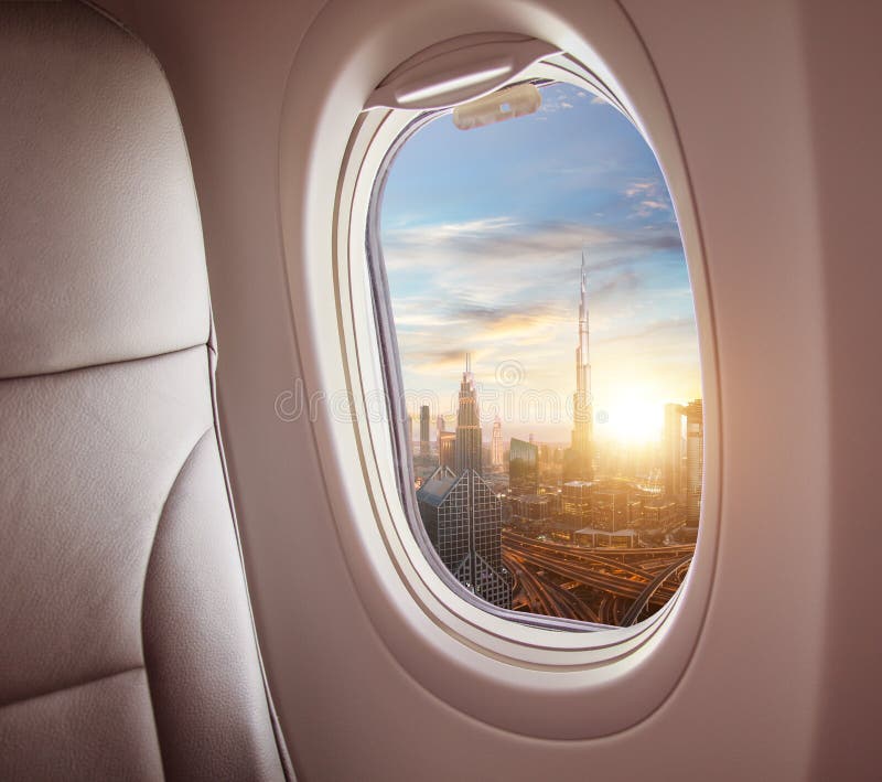 Airplane interior with window view of Dubai city