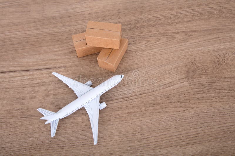 An Airplane Model and a Courier Shipping Box Model on the Table Stock