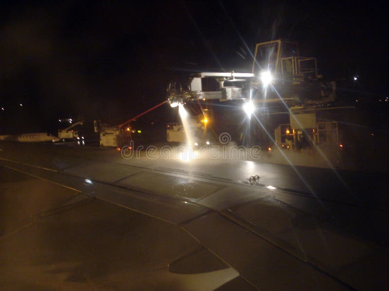 Airport Charles de Gaulle / Paris, France - January 2, 2010: Airport maintenance specialists spray anti-freeze liquid on the aircr stock image Airport Charles de Gaulle / Paris, France - January 2, 2010: Airport maintenance specialists spray anti-freeze liquid on the aircr stock image