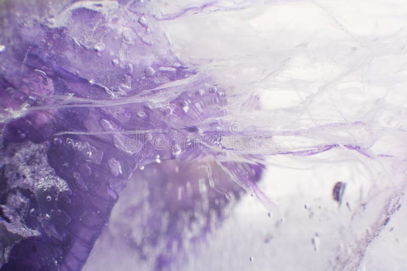 Airy delicate bubbles flowing through ice with purple colors underneath 2 stock photos