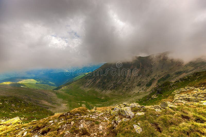 Ajardine con las montañas de Fagaras en Rumania y nubes fotografía de archivo libre de regalías Ajardine con las montañas de Fagaras en Rumania y nubes fotografía de archivo libre de regalías