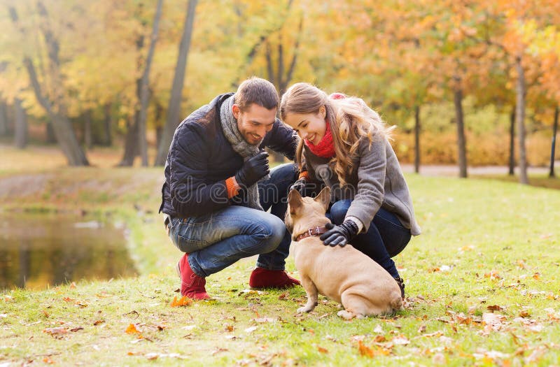 Ajouter de sourire au chien en parc d'automne. Soin, animaux, famille, saison et concept de personnes - les ajouter de sourire au chien en automne se garent