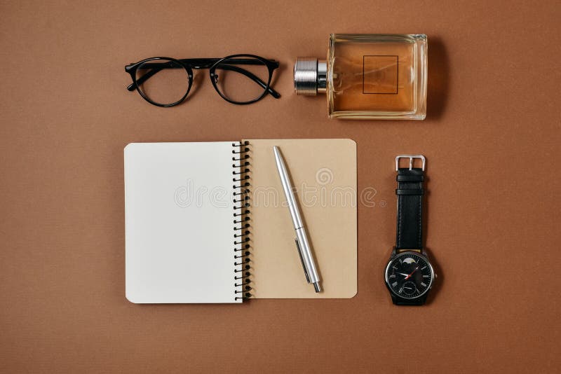 Ajuste dos acessórios masculinos à moda com uma pena, um perfume, um pulso de disparo, um bloco de notas e uns vidros no fundo ma imagem de stock royalty free Ajuste dos acessórios masculinos à moda com uma pena, um perfume, um pulso de disparo, um bloco de notas e uns vidros no fundo ma imagem de stock royalty free