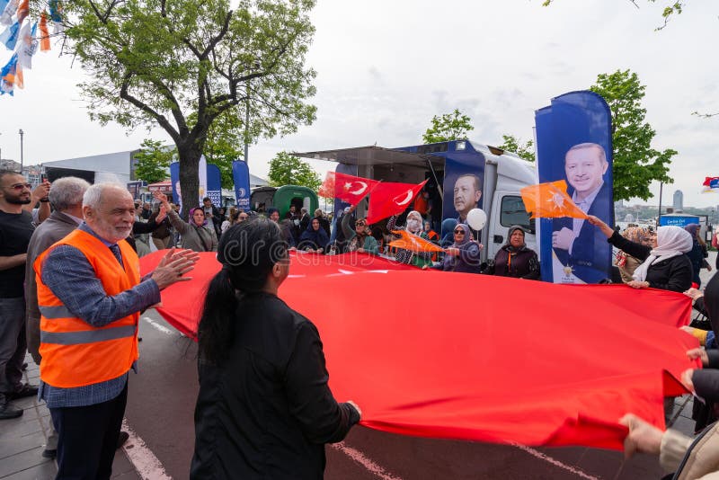 Istanbul, Turkey - May 3 2023: AK Party supporters waving a big Turkish flag in front of AK Party tent in the neighbourhood of Uskudar during 2023 elections. Istanbul, Turkey - May 3 2023: AK Party supporters waving a big Turkish flag in front of AK Party tent in the neighbourhood of Uskudar during 2023 elections