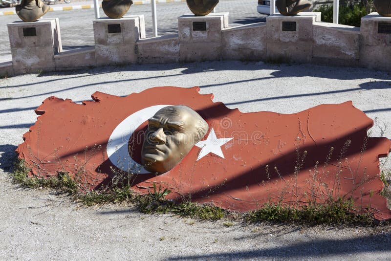 AKSARAY-KONYA LANDSTRASSE, DIE TÜRKEI - 7. MAI 2015: Foto des Skulpturkopfes von Ataturk gegen einen Hintergrund der türkischen F lizenzfreies stockbild AKSARAY-KONYA LANDSTRASSE, DIE TÜRKEI - 7. MAI 2015: Foto des Skulpturkopfes von Ataturk gegen einen Hintergrund der türkischen F lizenzfreies stockbild