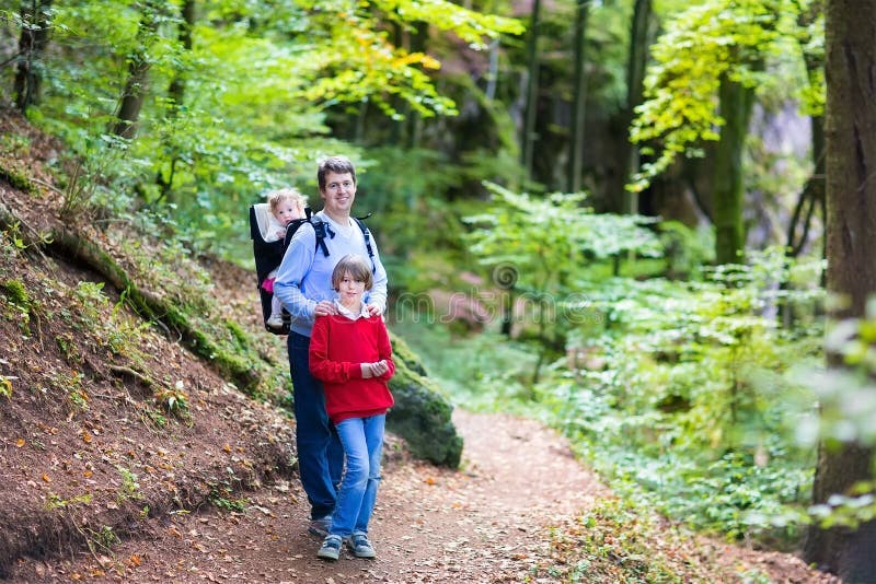 Aktiv fader med ungar som fotvandrar i klippa och skog arkivbilder Aktiv fader med ungar som fotvandrar i klippa och skog arkivbilder