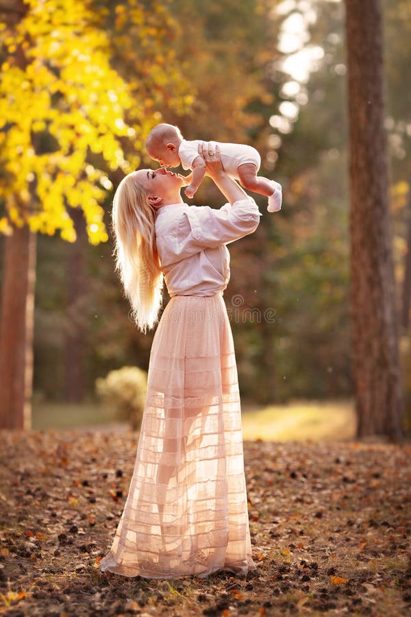 Aktiv mor som spelar med lilla barn i en park Mamma med bebisen i skogslandskapet Autumn arkivfoto Aktiv mor som spelar med lilla barn i en park Mamma med bebisen i skogslandskapet Autumn arkivfoto